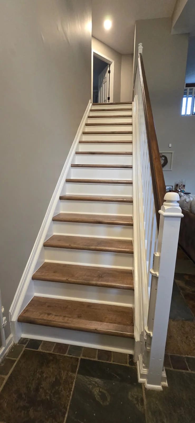 Modern farmhouse interior staircase with wood and white risers.